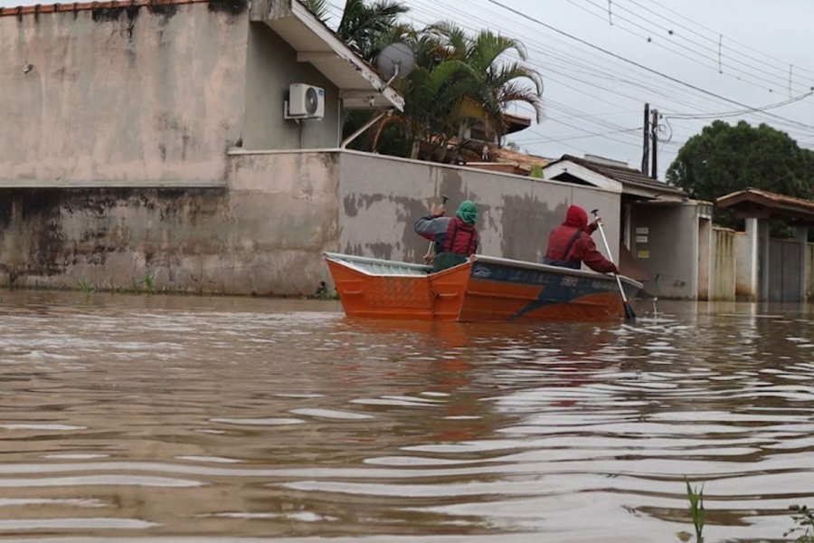 Moradores se deslocam de barco após alagamento em ruas de Atibaia